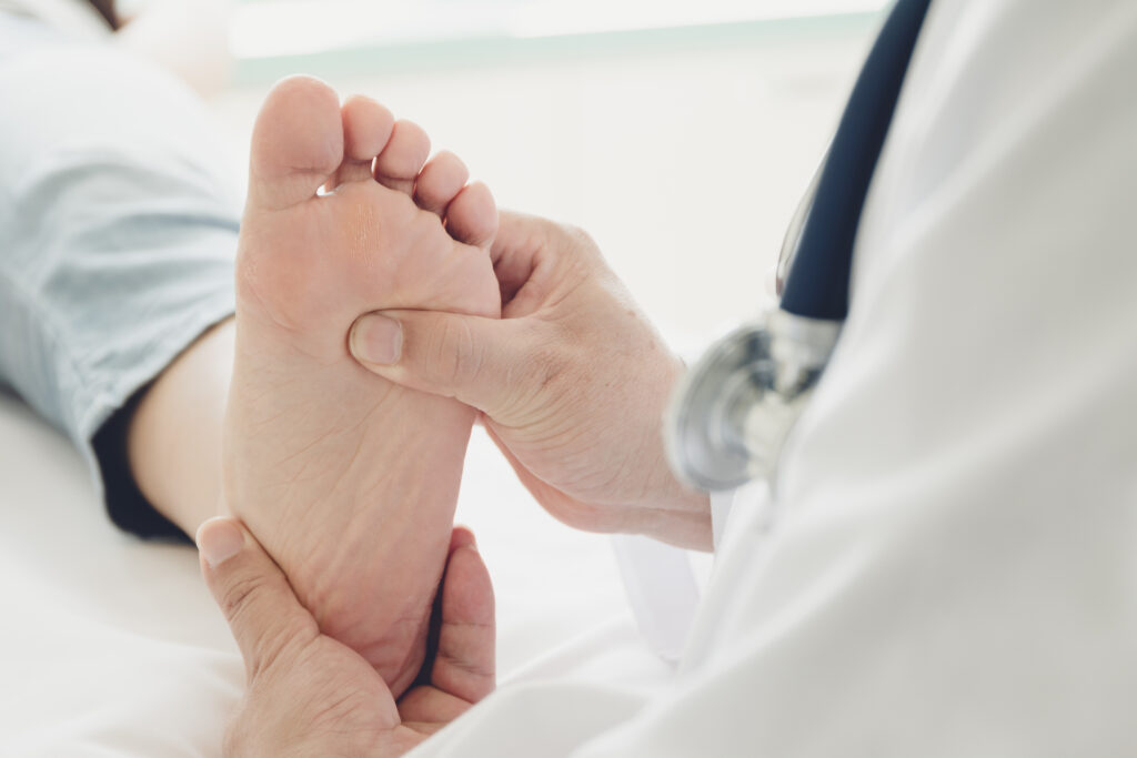 Healthcare professional examining a patient's foot for diabetic foot ulcers. Adherence to diabetic foot ulcer dressing guidelines is crucial for proper wound healing and infection prevention.