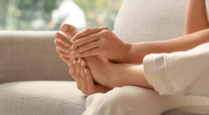 Person gently massaging their foot, promoting relaxation and foot health.