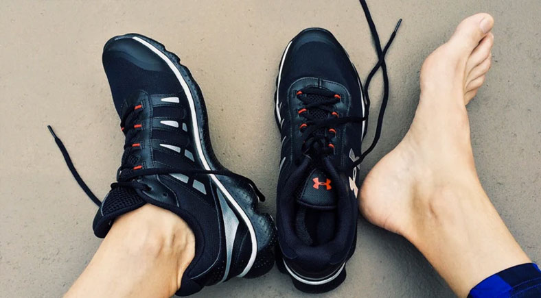 Person wearing proper footwear with one foot bare, highlighting the importance of proper shoe choice for foot health.