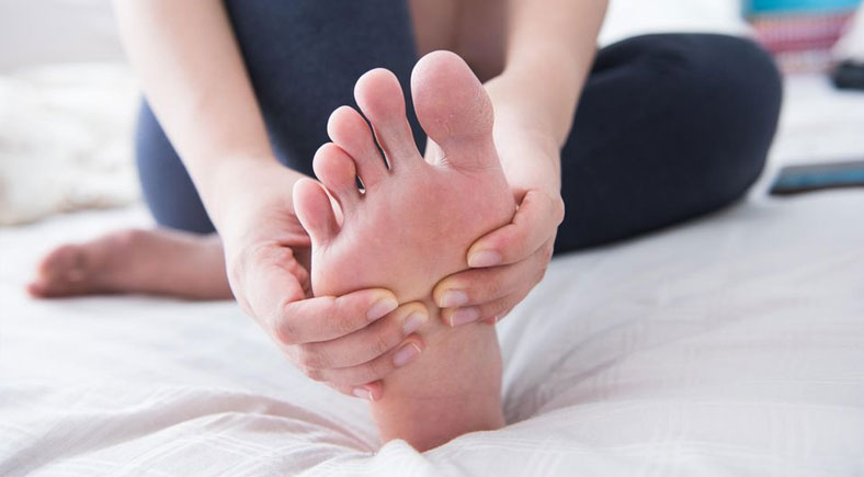 A person holding their foot, focusing on relieving foot pain and promoting recovery at Foot & Wound Institute.