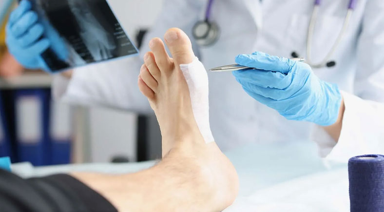 A close-up of a doctor wearing gloves and holding medical tools, treating a patient's foot with a small bandage. An X-ray is visible in the background.